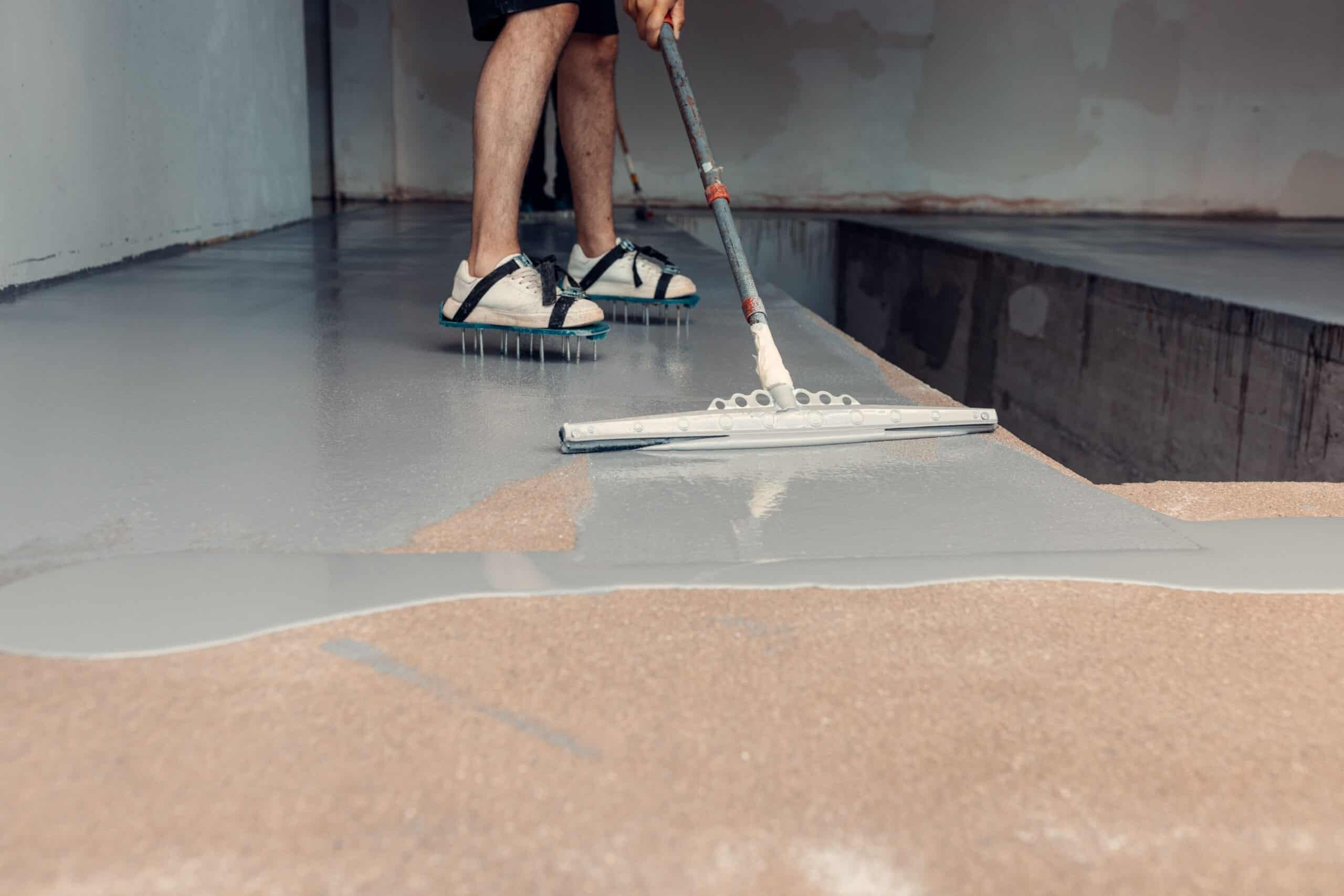 Installer applying grey epoxy floor coating